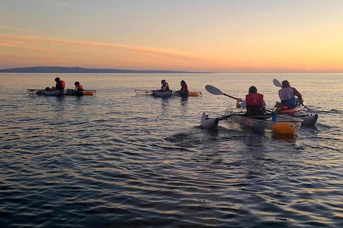 un gruppo di persone in kayak sull'acqua al tramonto