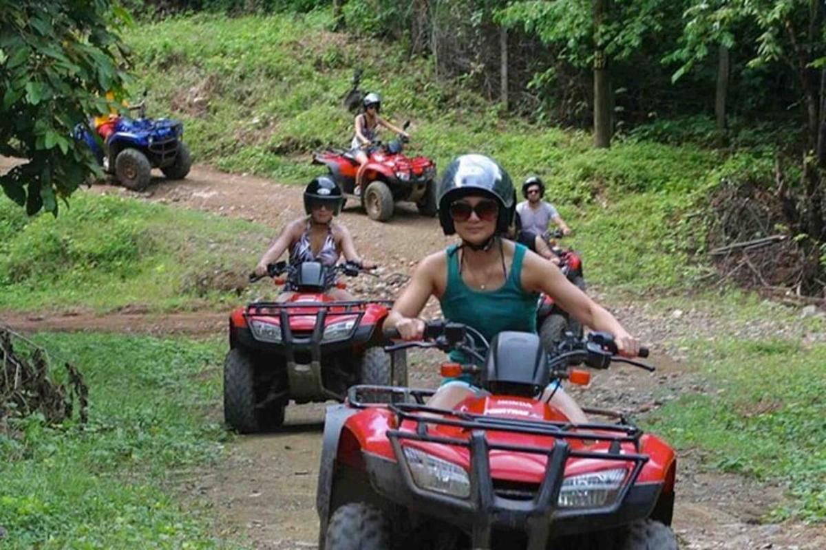 un grup de persones que condueixen quads per un camí de terra
