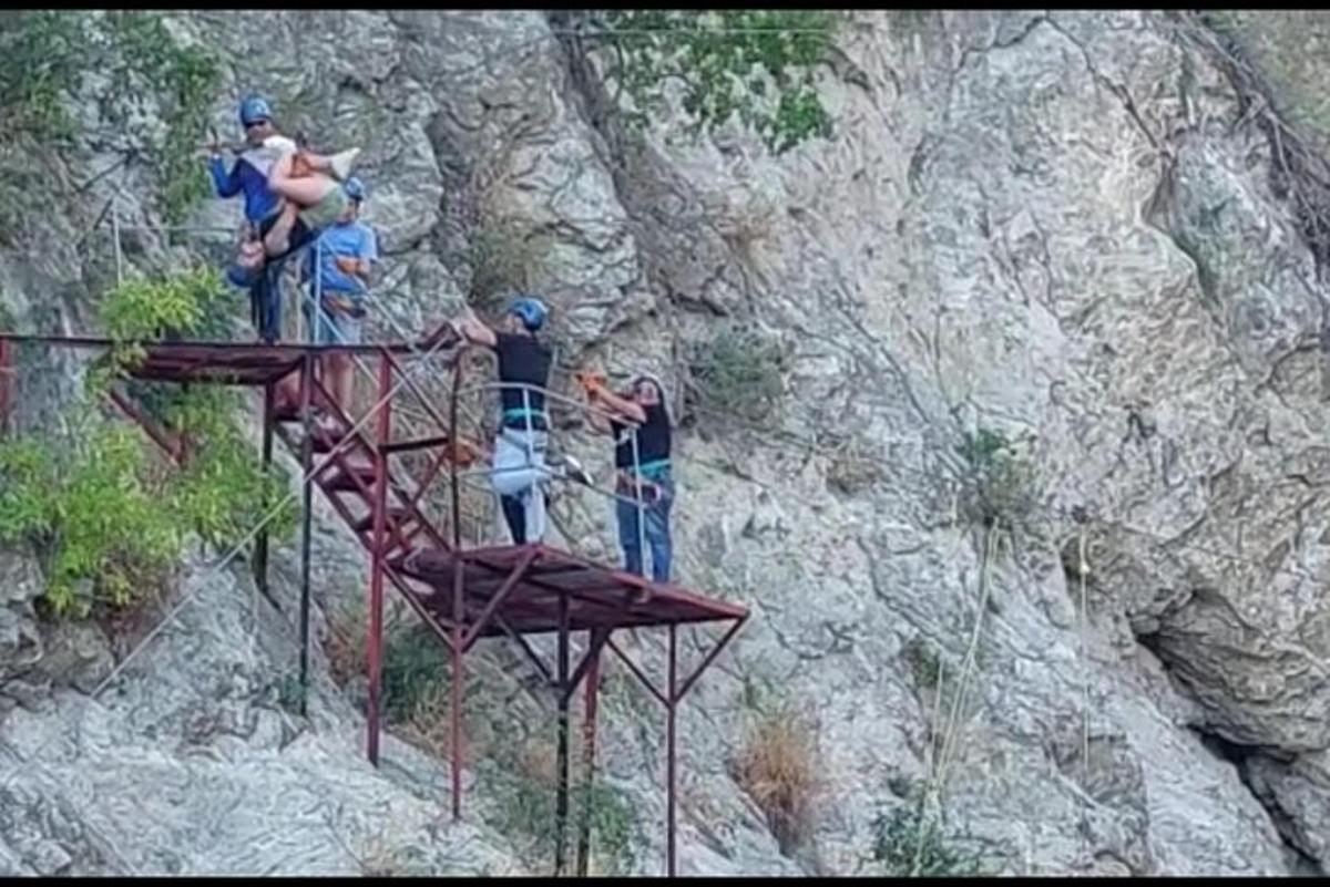 hópur fólks sem stendur á málmgrind á fjalli