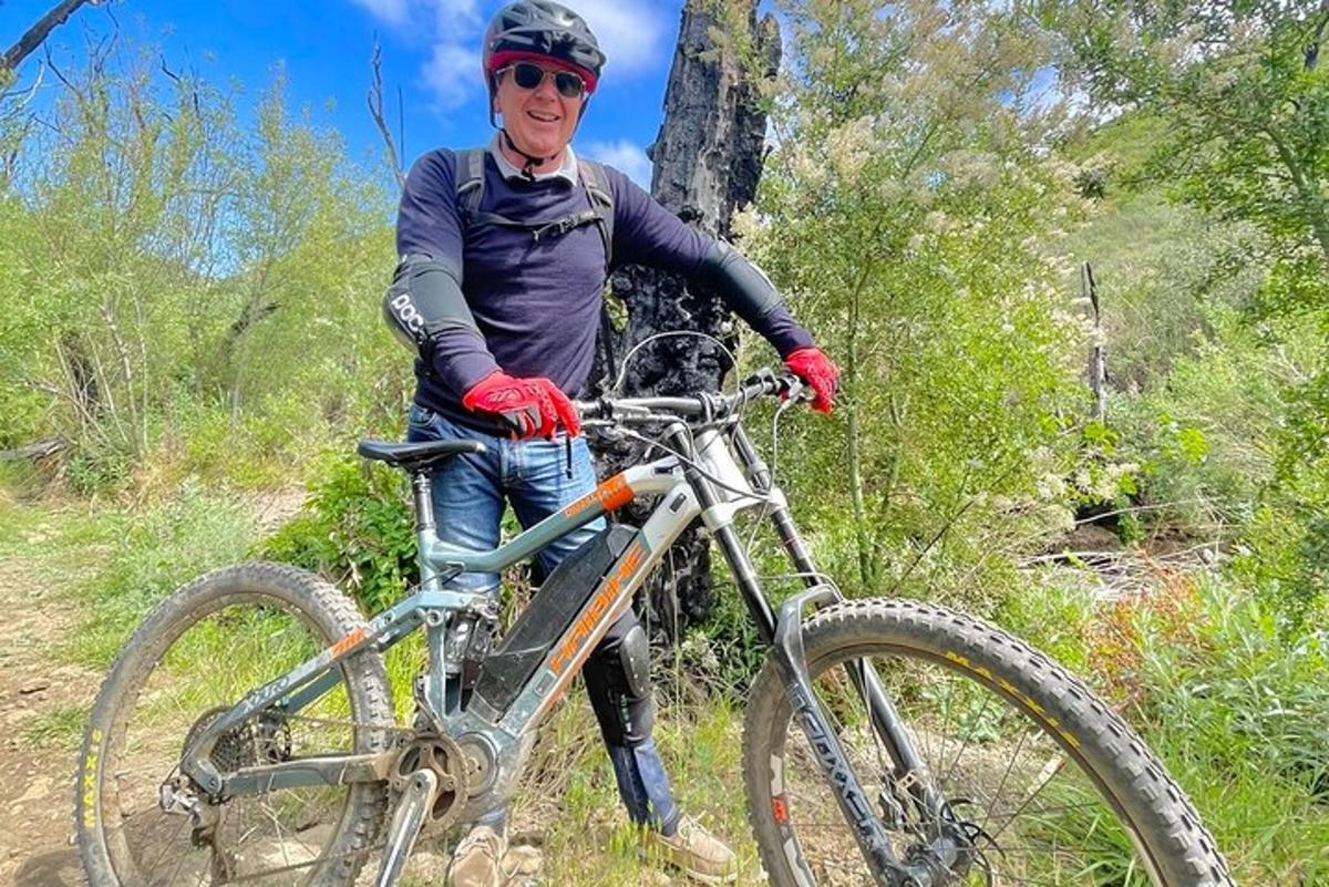 un uomo in piedi accanto a una bicicletta su un sentiero