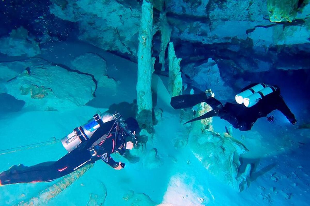 dues persones nedant a l'aigua d'una cova