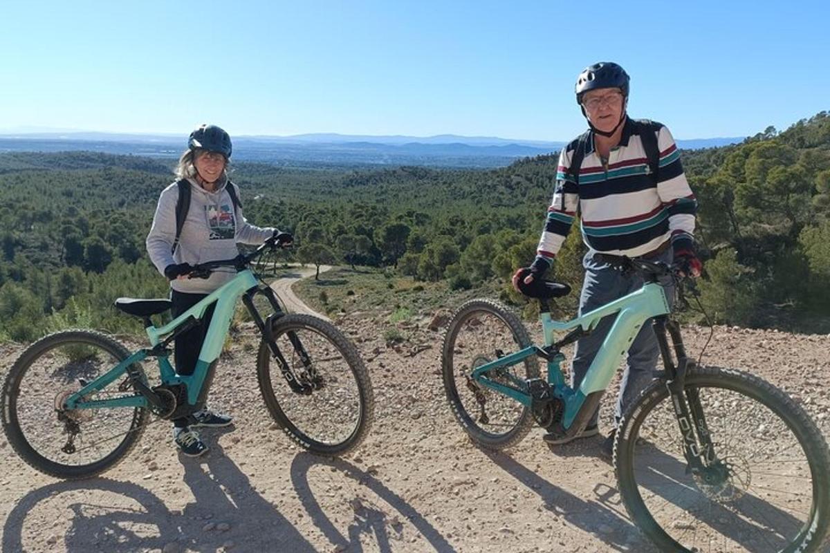 twee mensen staan op hun fietsen op een heuvel
