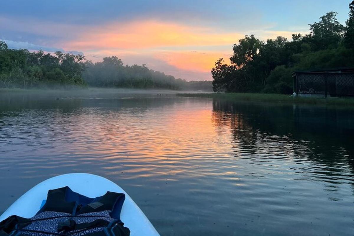 Un barco en un río con una puesta de sol al fondo