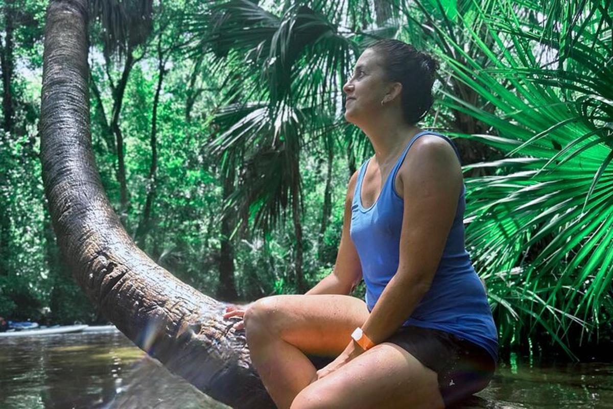 una mujer sentada en un árbol en la jungla