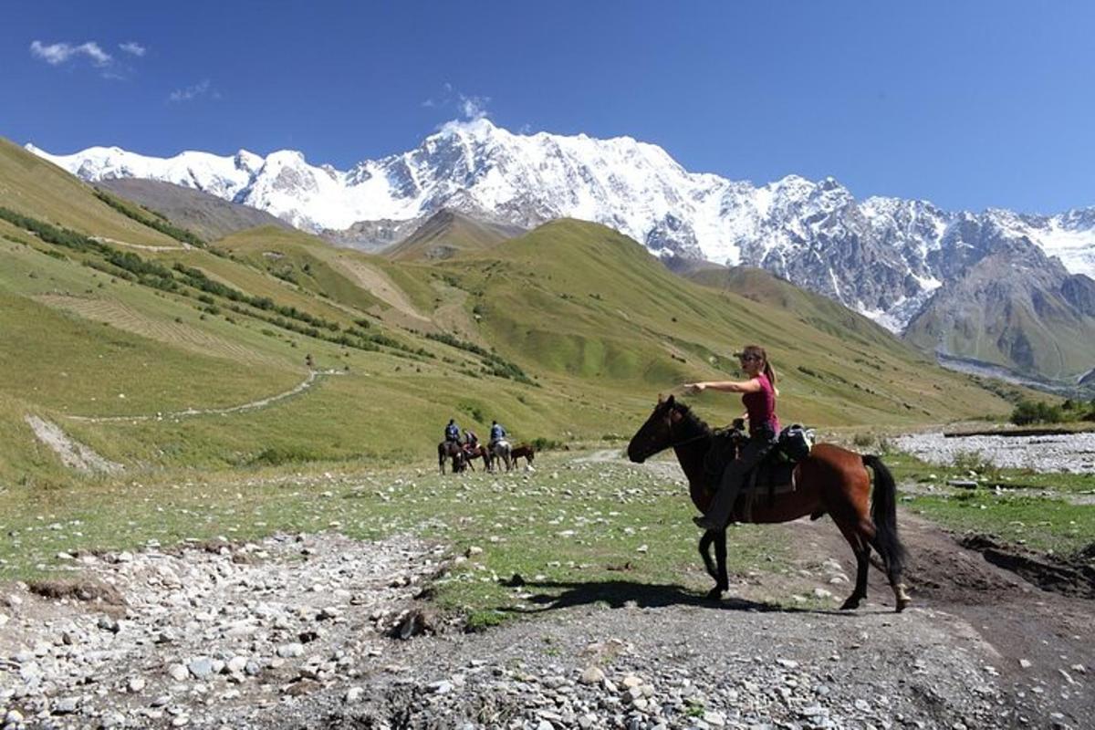 een groep mensen die te paard door de bergen rijden