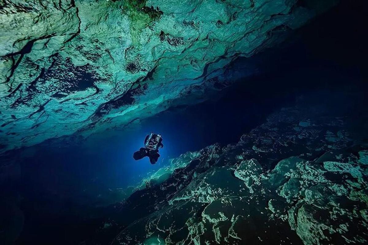 una persona che nuota nell'acqua in una grotta sottomarina