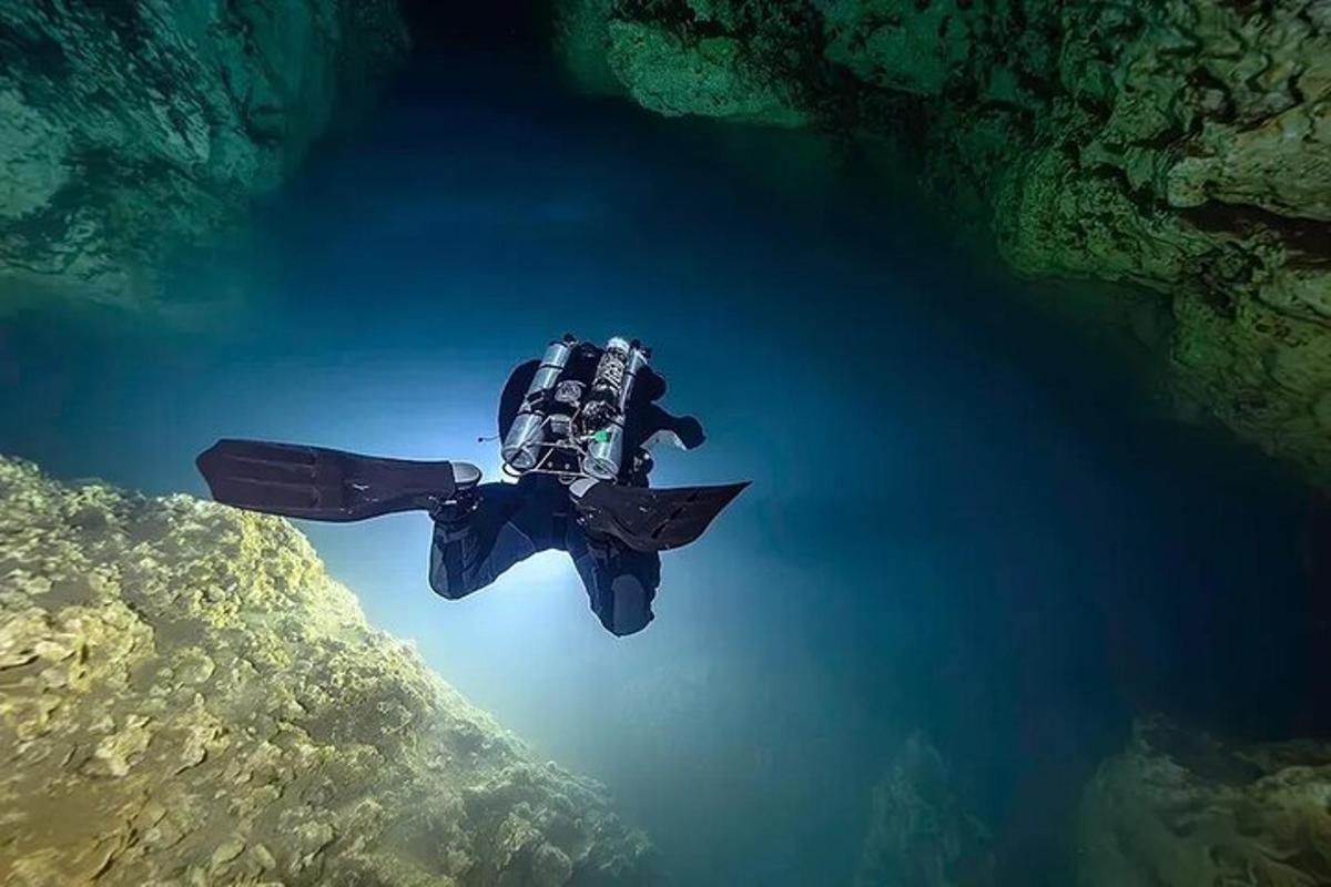 un subacqueo si sta immergendo nell'acqua di una grotta
