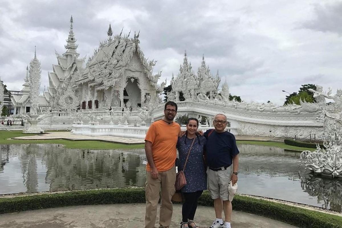 un home i una dona drets davant d'un temple blanc