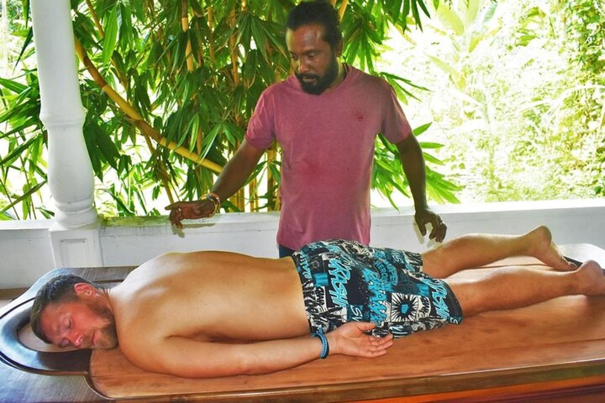 un uomo sdraiato su un lettino da massaggio con un uomo in piedi