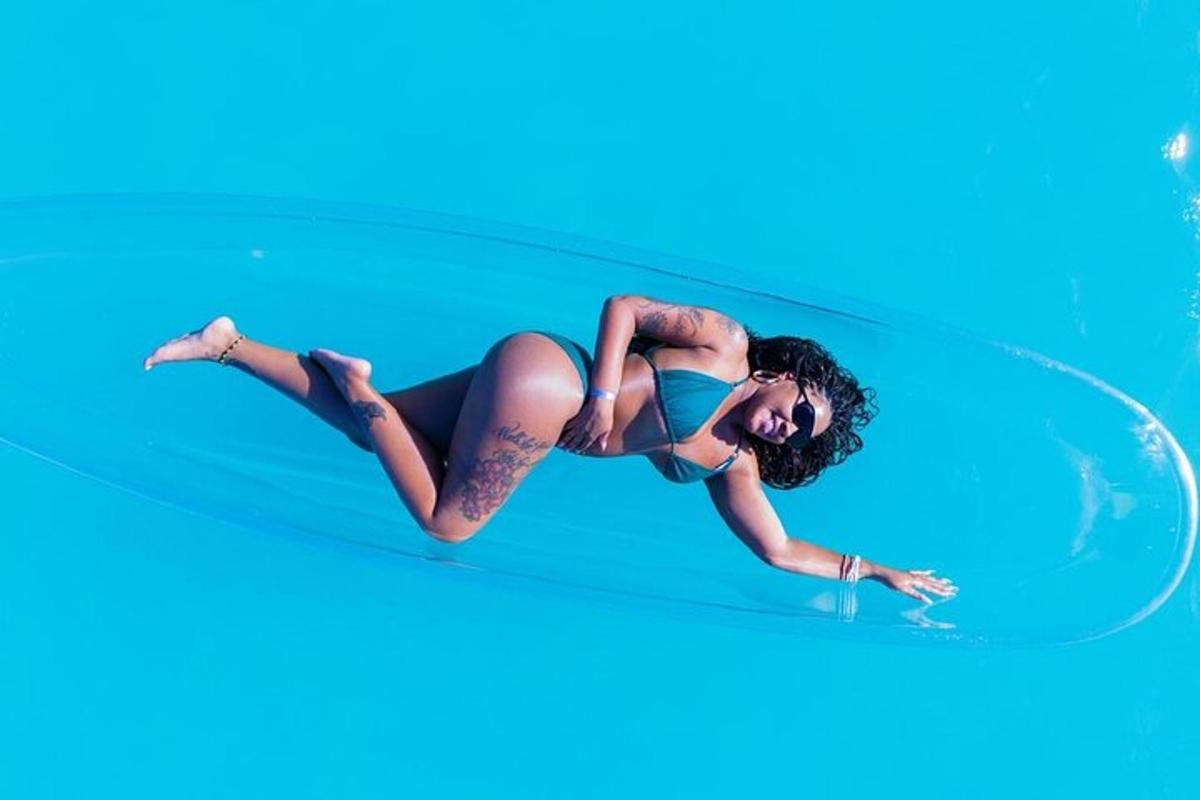 uma mulher de biquíni deitada em uma prancha de surfe
