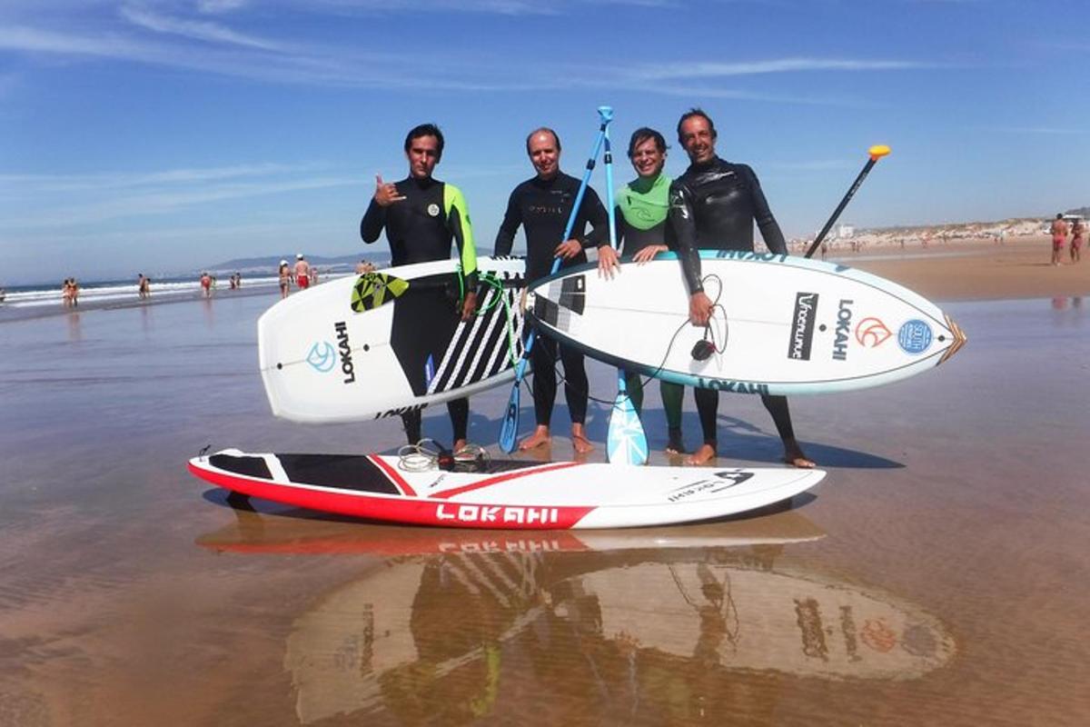 Grupa ludzi stojąca na plaży z deskami surfingowymi