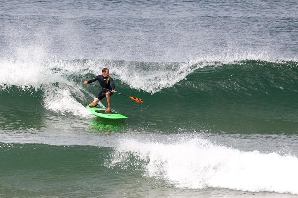 Un hombre montando una ola en una tabla de surf en el océano