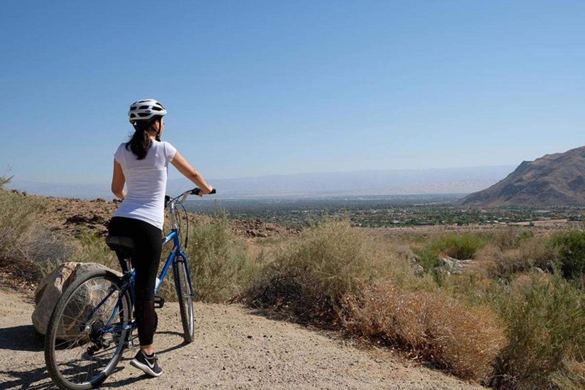 a woman riding a bike on a dirt road