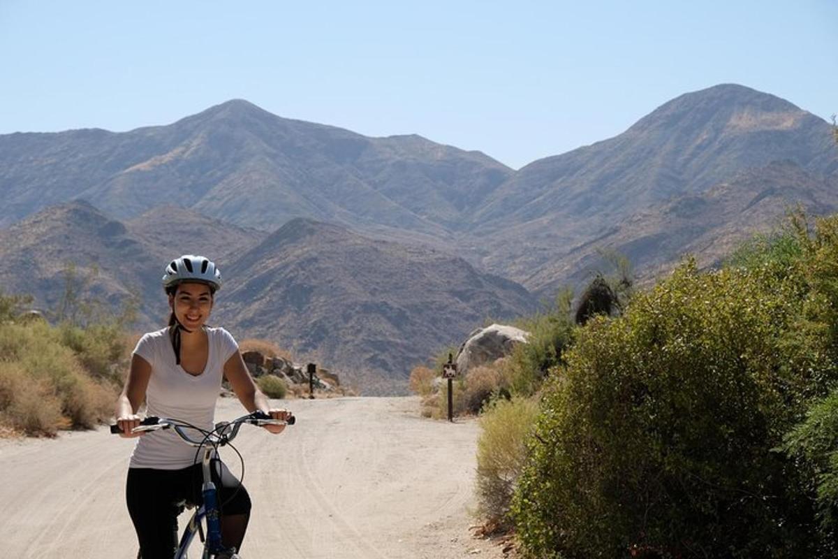 a woman riding a bike on a dirt road