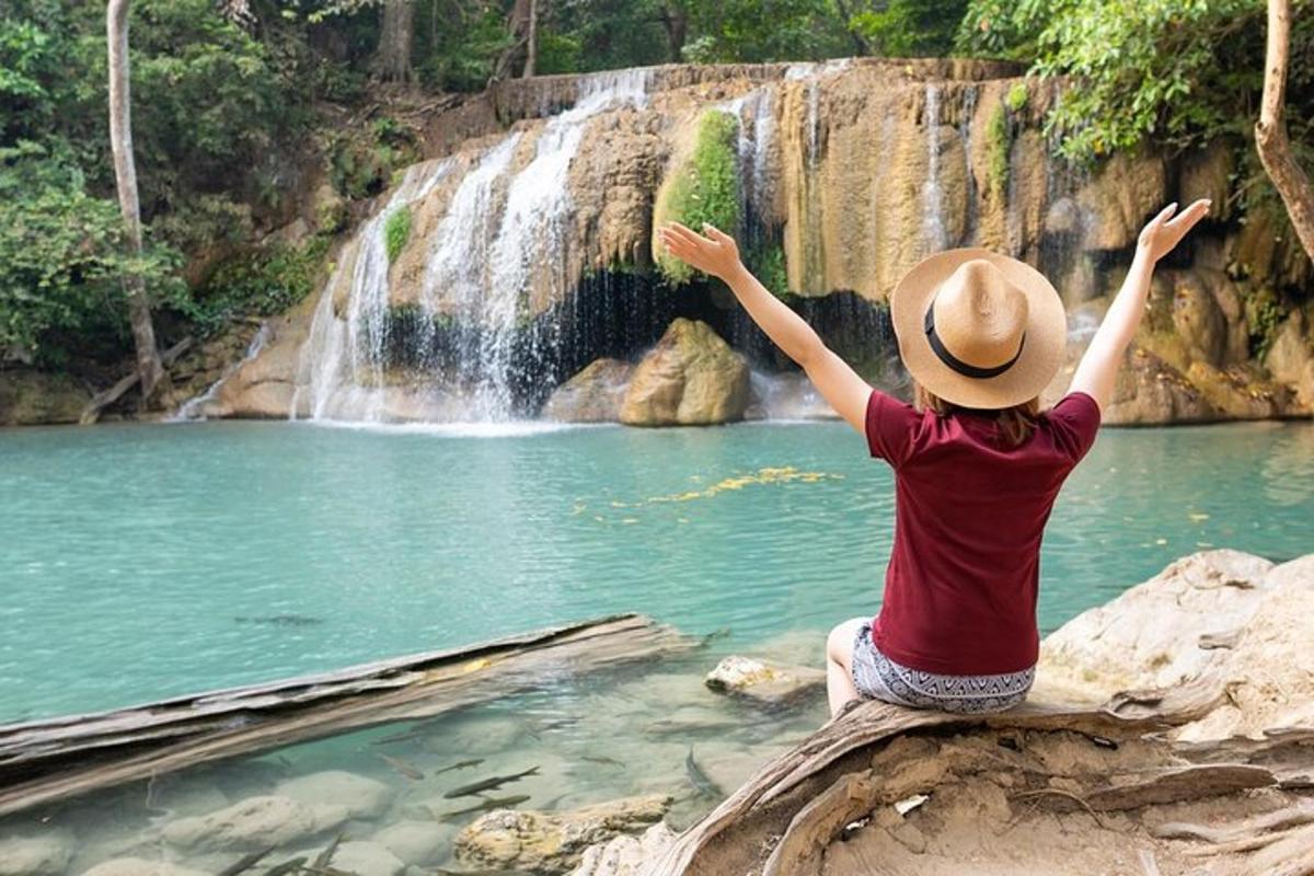 eine Person, die auf einem Felsen vor einem Wasserfall sitzt