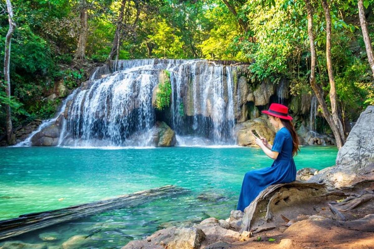 una donna con un cappello in piedi davanti a una cascata