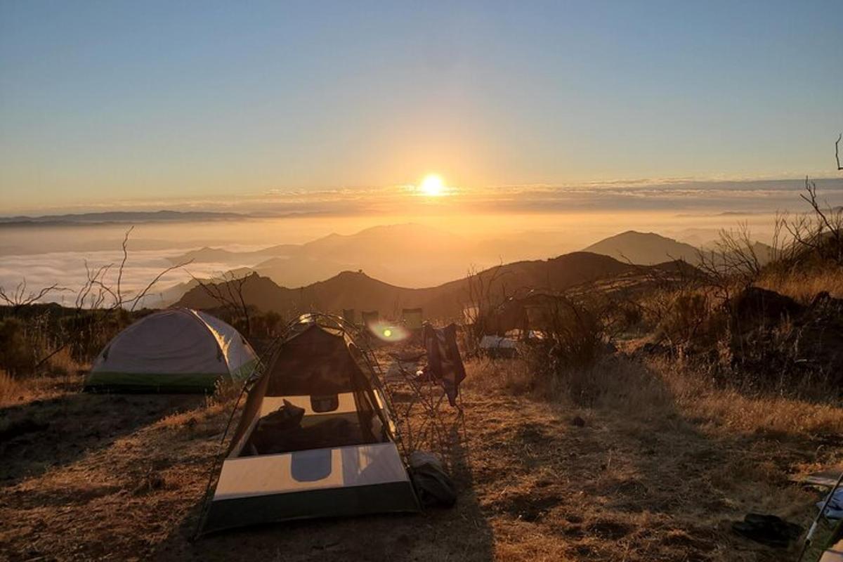 Un camping con una tienda de campaña y el sol en el cielo