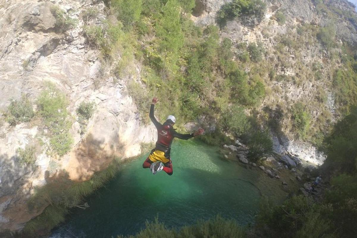 un uomo sta saltando in aria sopra uno specchio d'acqua