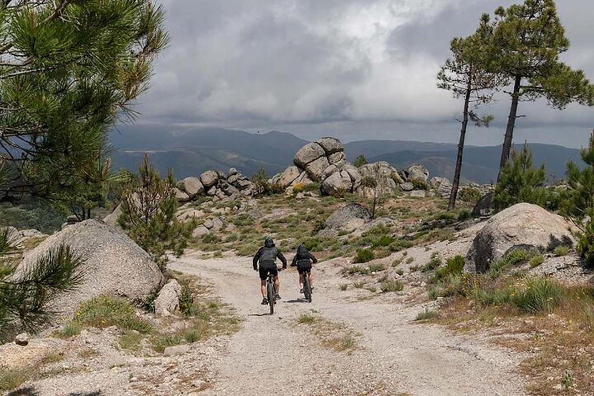 two people riding bikes down a dirt road
