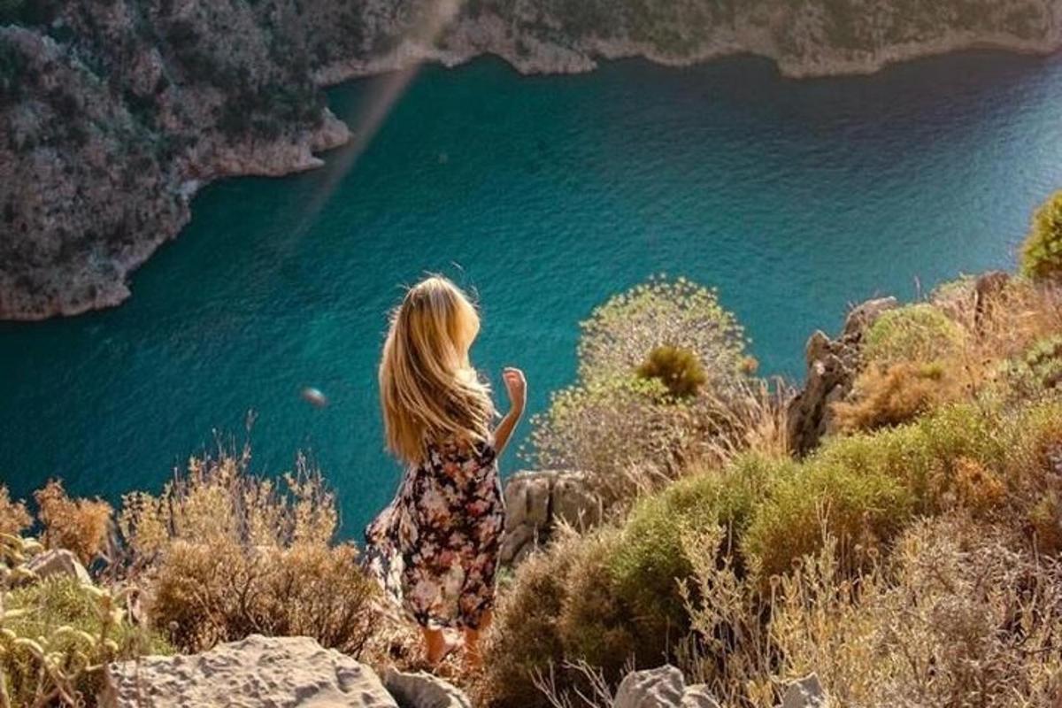 žena stojící na kopci a dívající se na jezero