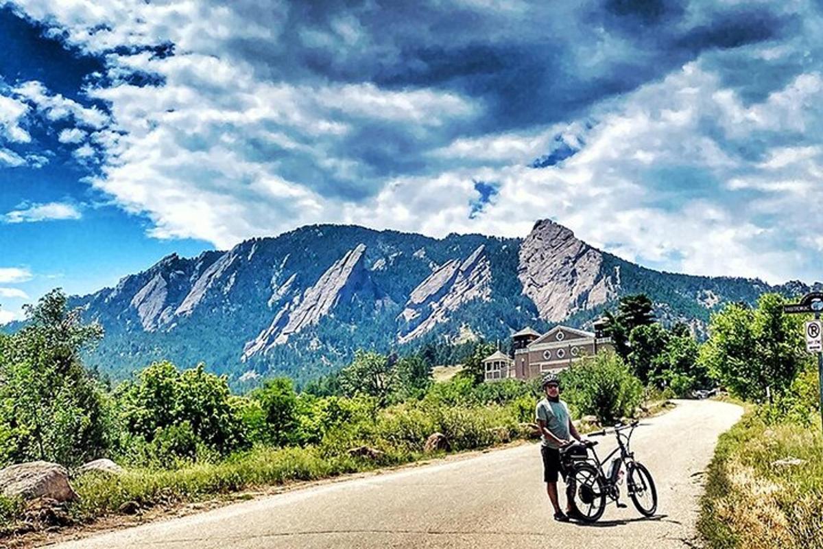 un uomo in piedi su una strada con una bicicletta