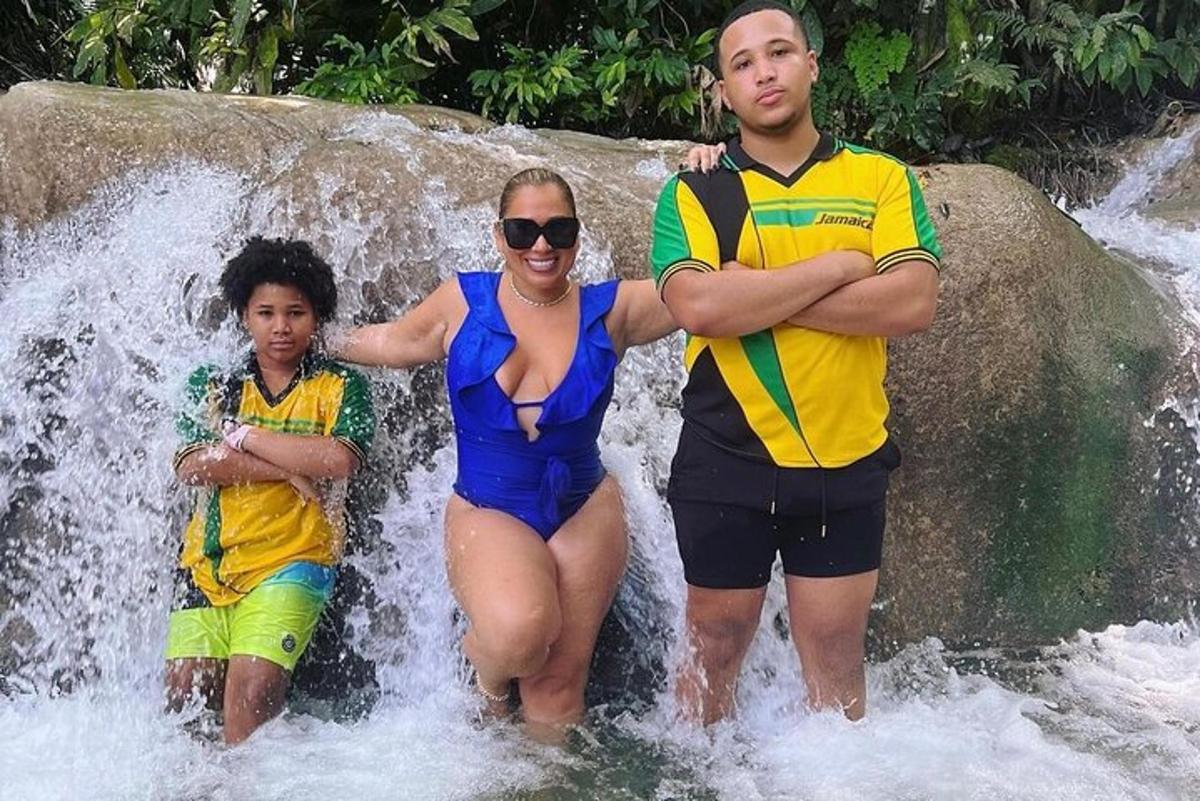 seorang wanita dan seorang lelaki dan seorang kanak-kanak berdiri di dalam air terjun