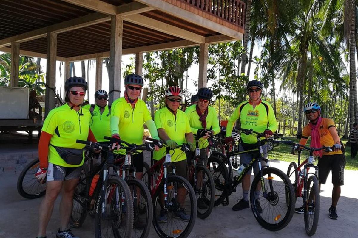 un gruppo di persone in magliette gialle in posa con le loro biciclette