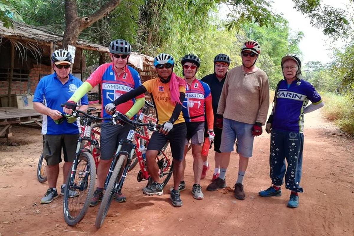 um grupo de pessoas com bicicletas em uma estrada de terra