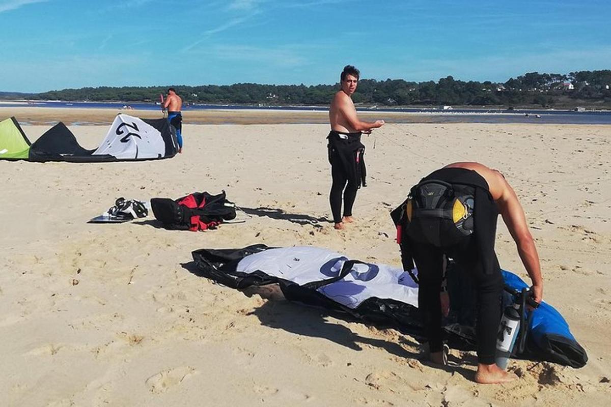 due uomini in piedi su una spiaggia con un aquilone sulla sabbia