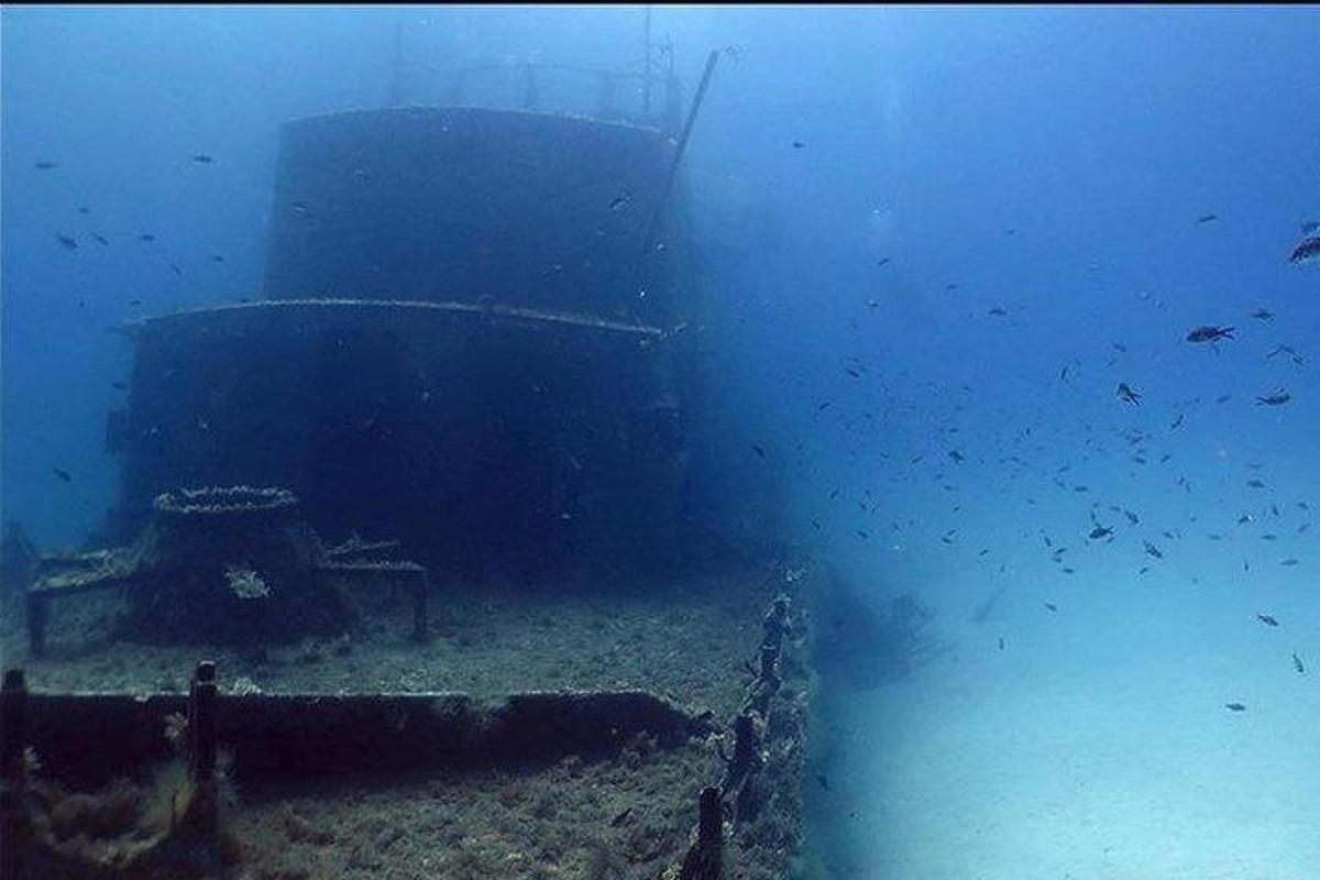 a large boat in the ocean with fish in the water