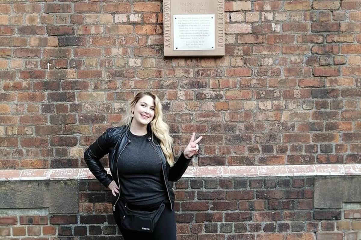 a woman standing in front of a brick wall