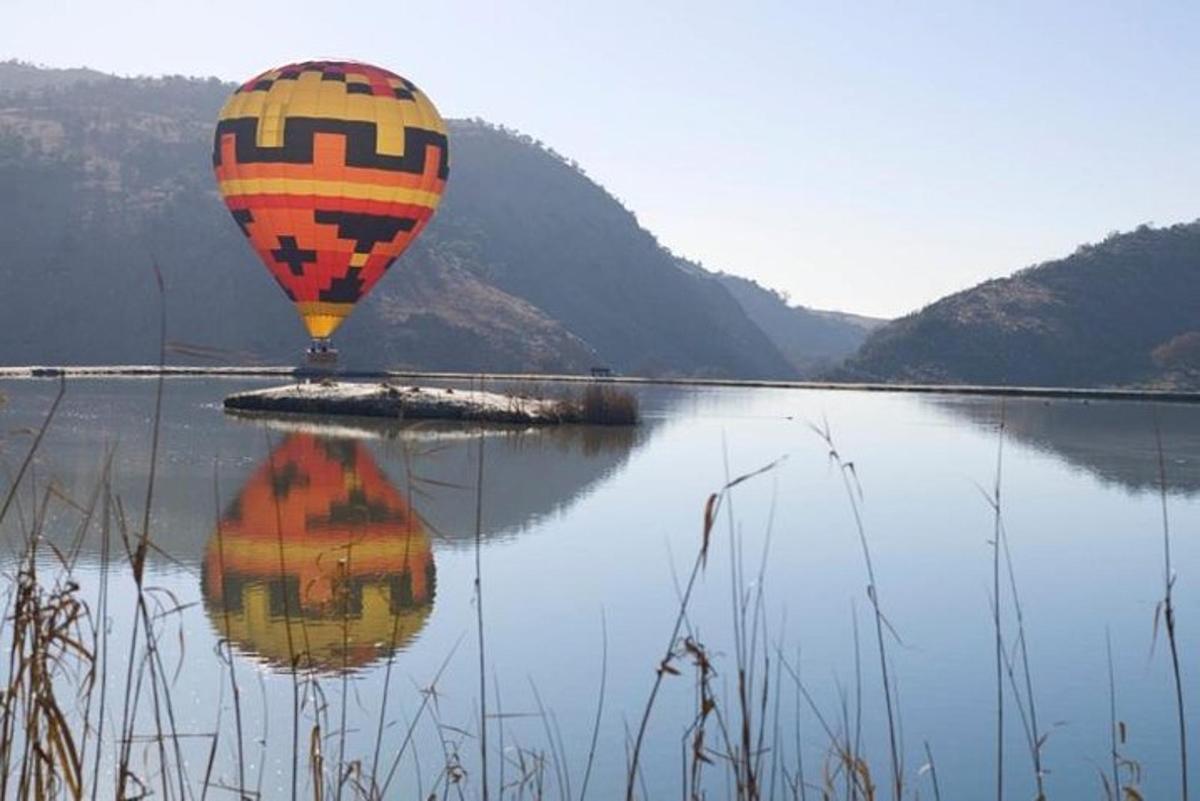 horkovzdušný balón letící nad vodní plochou