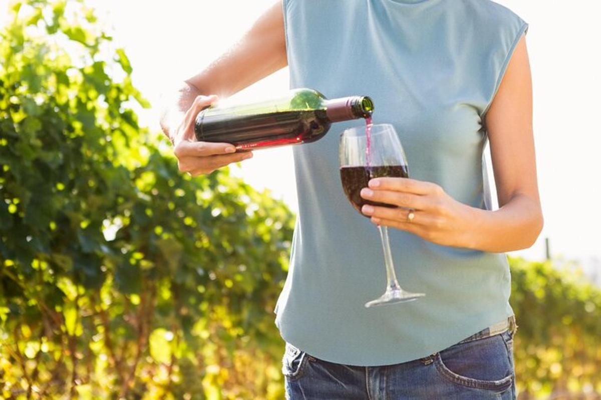 een vrouw die een fles wijn en een glas vasthoudt