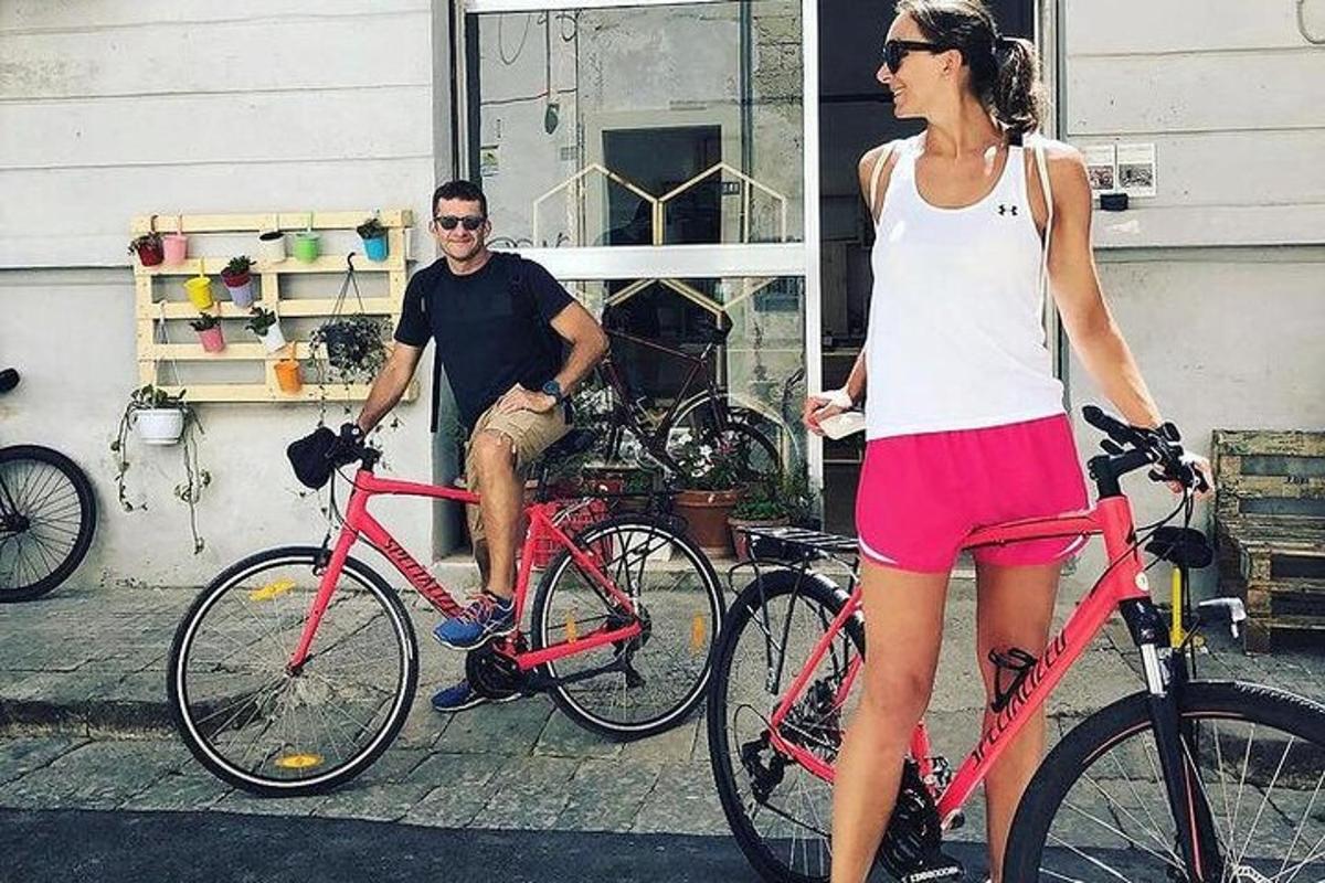 en mand og en kvinde står ved siden af to cykler