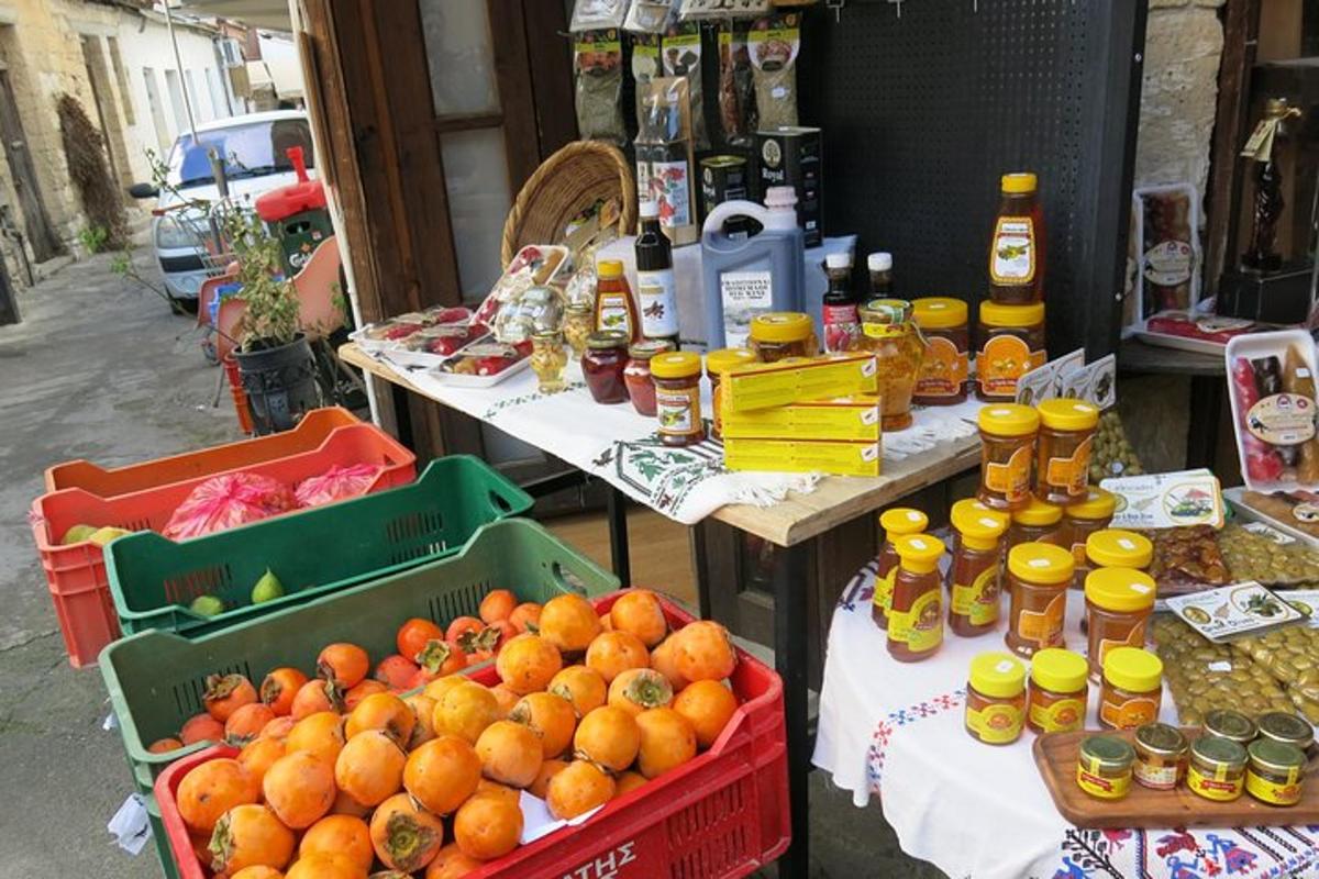 een tafel met flessen honing en manden met sinaasappels
