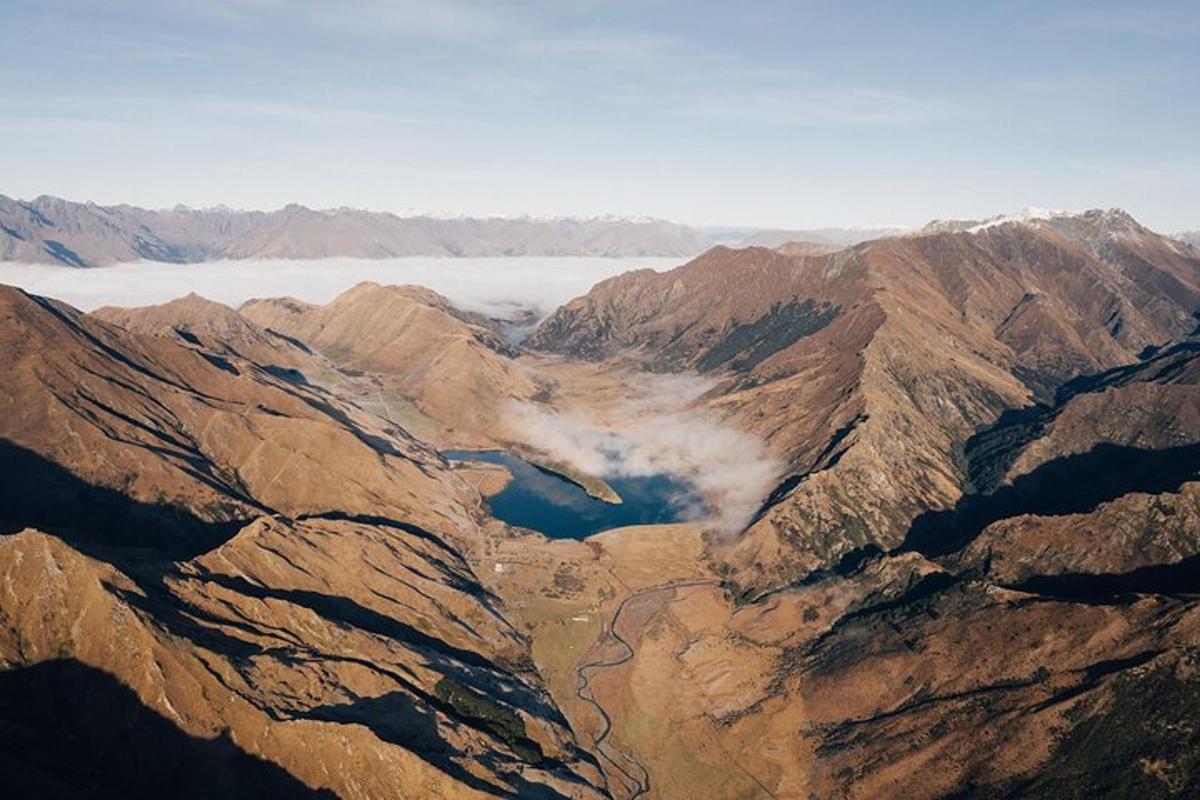 an aerial view of a mountain range with a body of water