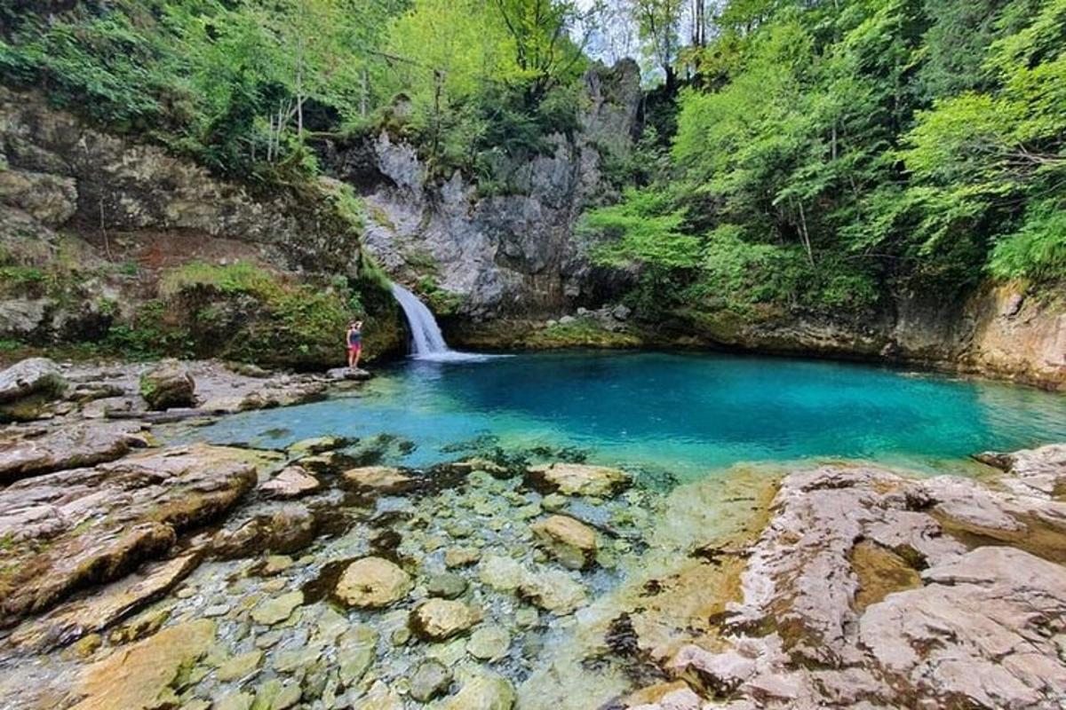 una persona dempeus en un bassal d'aigua en un riu