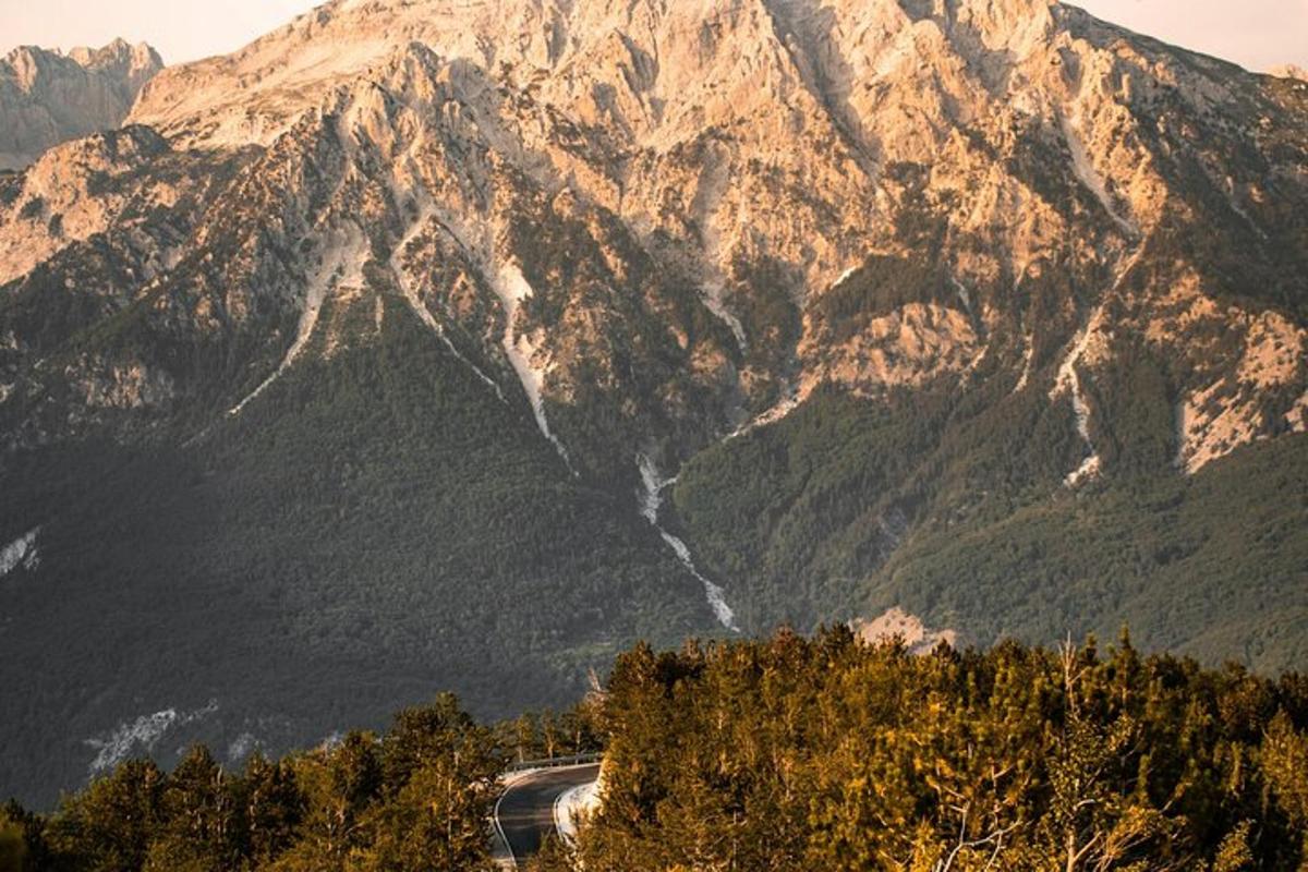 uma estrada sinuosa em frente a uma cadeia de montanhas