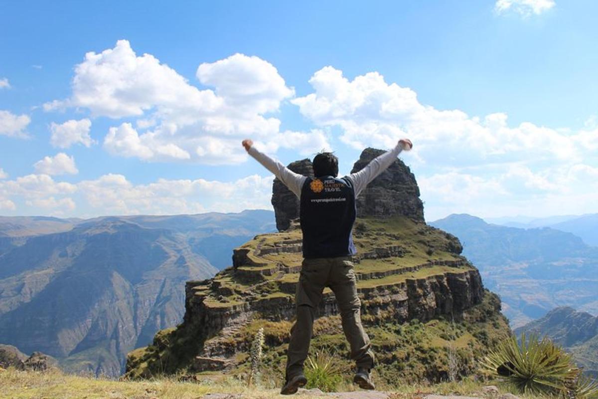 seorang pria berdiri di atas gunung dengan kedua tangannya terentang