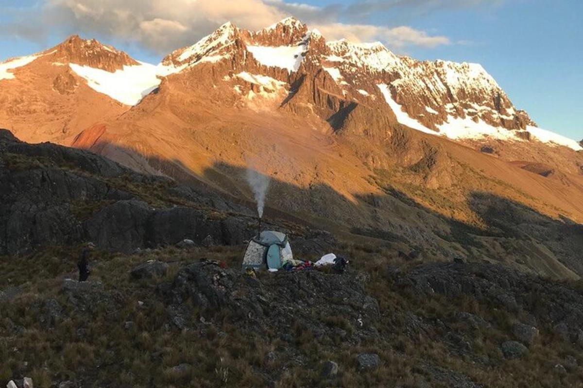 seseorang dengan ransel duduk di gunung