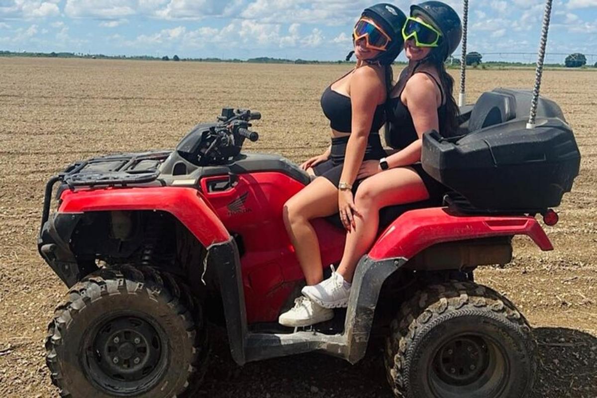 zwei Frauen sitzen auf einem Geländefahrzeug auf einem Feld