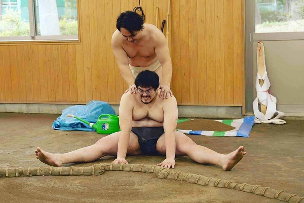 um homem deitado no chão em uma sala com outro homem