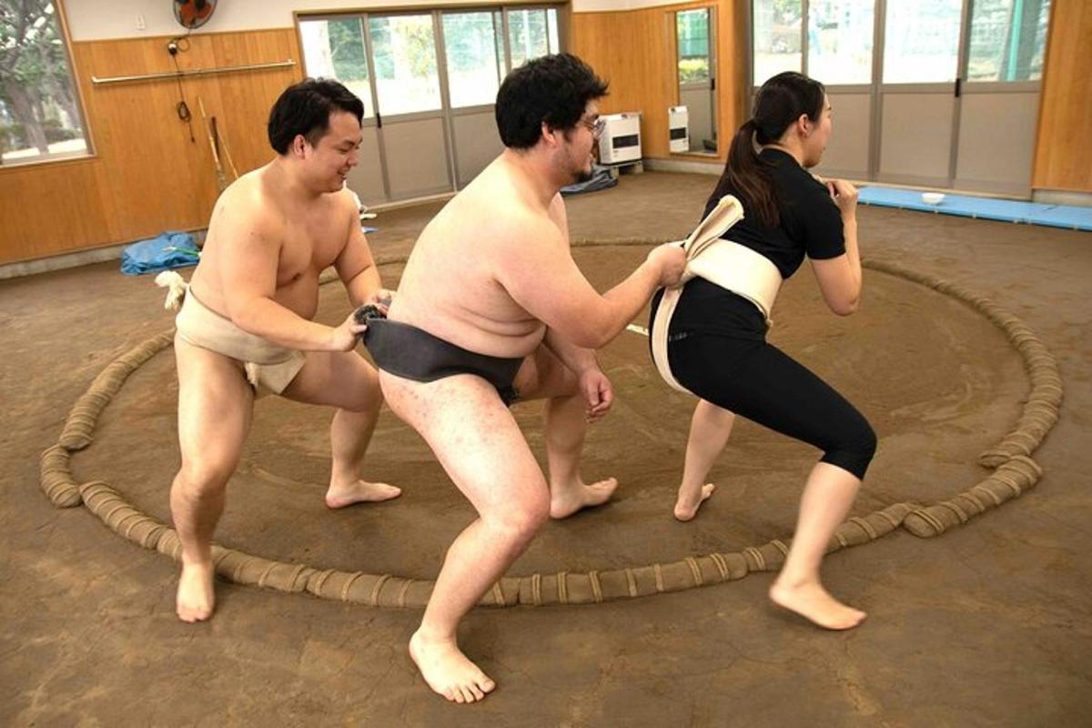 três homens e uma mulher em um anel de corda