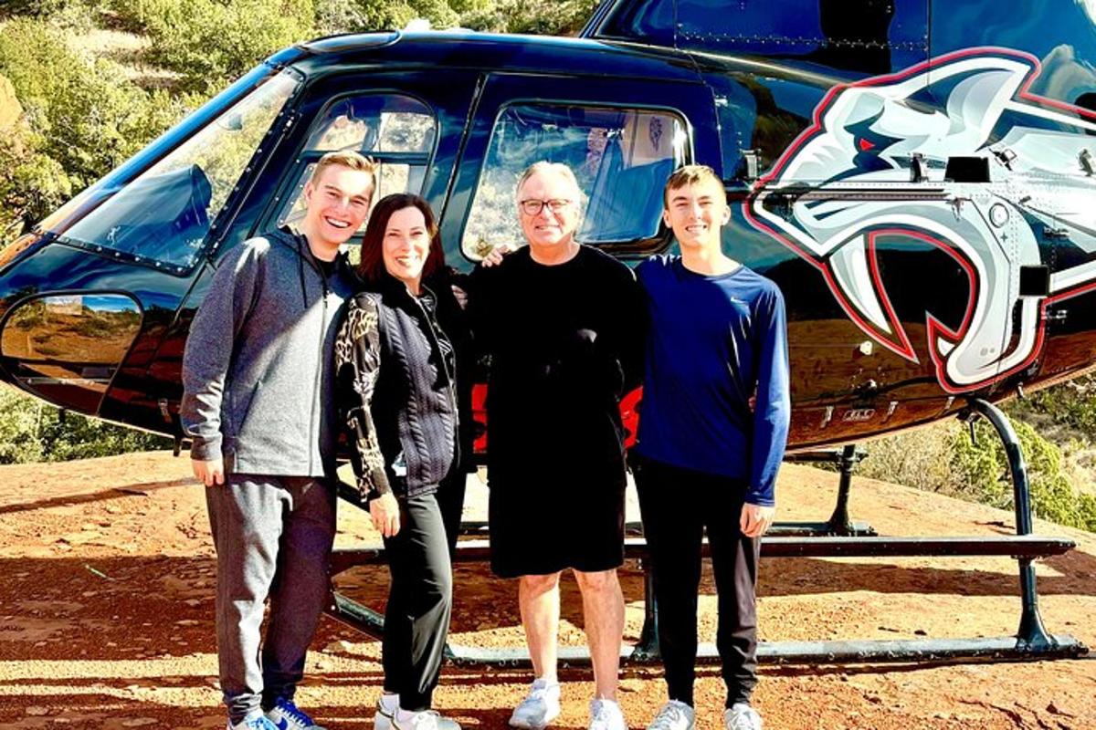 un grup de persones dempeus davant d'un helicòpter