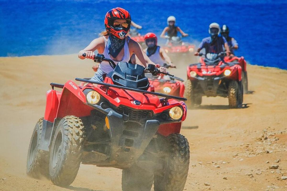 Un grupo de personas conduciendo vehículos todo terreno en la playa.