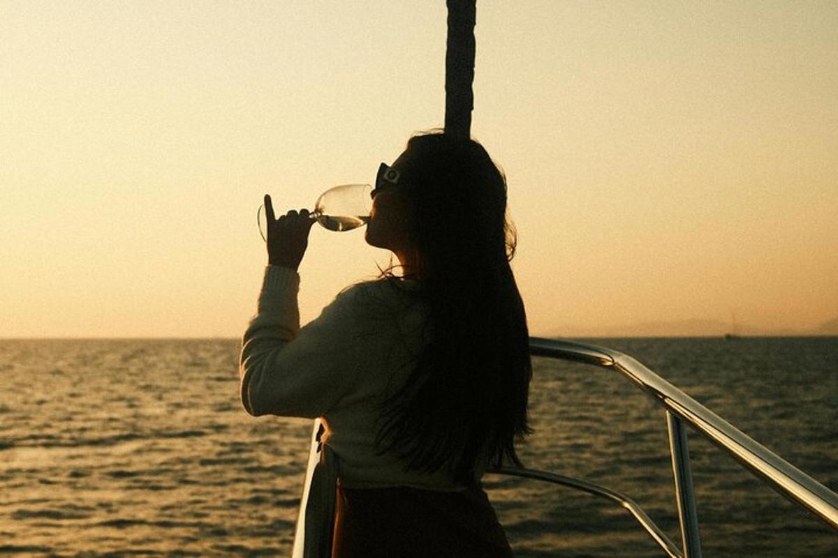 una mujer bebiendo una copa de vino en un barco