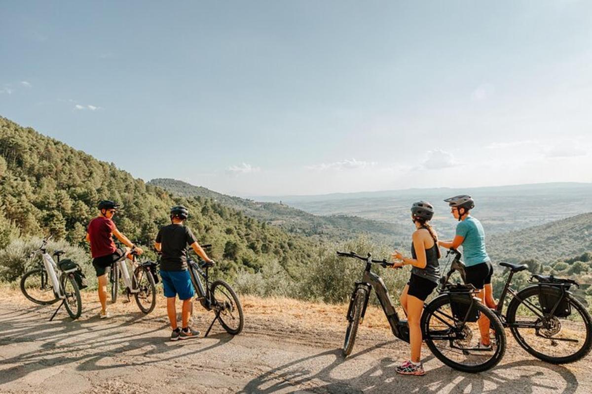 a group of people standing with bikes on a hill