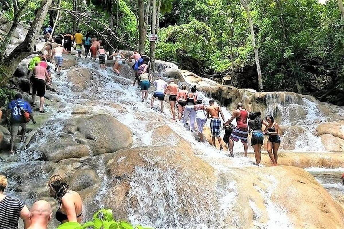 um grupo de pessoas caminhando sobre uma cachoeira