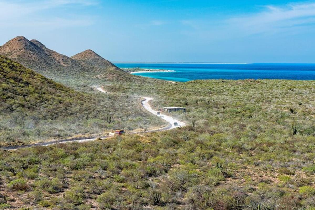 a winding road on a hill next to the ocean