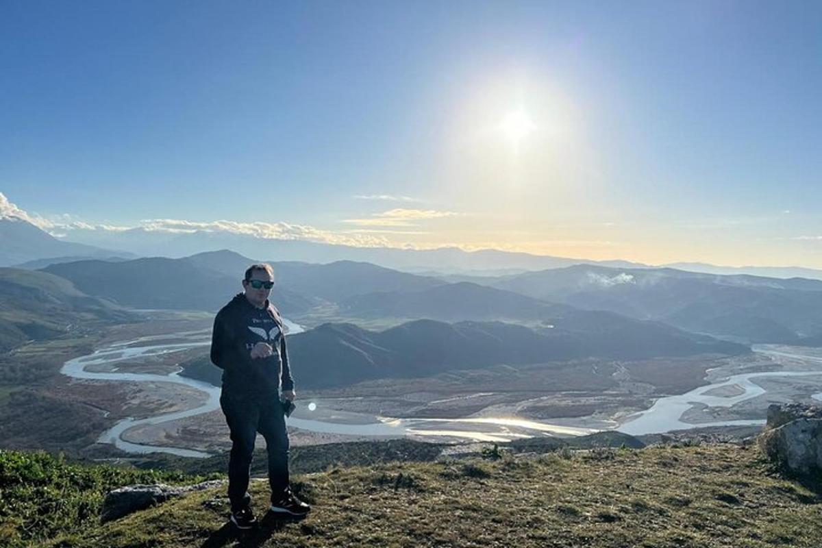 maður stendur á fjallstindi